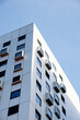 © anna.stasiia - Modern white building with square windows. Multistory apartment building. Minimalistic Stylish living block of flats. Facades of modern office building. Exterior texture pattern. Visual art