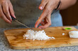 © Fabian Vargas - Cortando y picando vegetales y legumbres en casa sobre tabla de corte y cuchillo de cheff