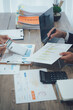 © Wicitr - Two business people talk project strategy at office meeting room. Businessman discuss project planning with colleague at modern workplace while having conversation and advice on financial data report.