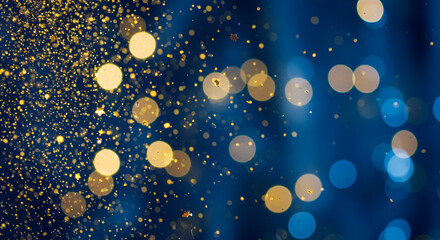 Elegant blue background with golden glitter and soft light bokeh effects