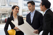 © khwanchai - Engineers and building designers stand looking at blueprints to plan the building construction design.