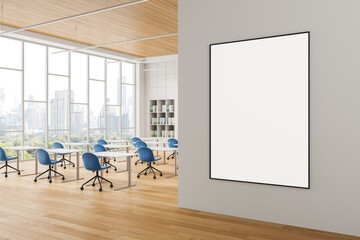 Poster - Blank poster on clean wall in bright modern office interior with city view through large windows and blue chairs arranged around white desks. 3D Rendering