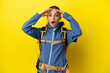 © luismolinero - Young mountaineer woman with a big backpack over isolated yellow background with surprise expression
