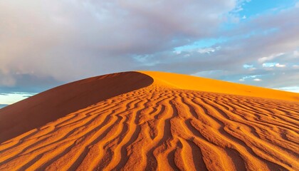 a breathtaking close-up view of a large desert sand dune with intricate ripples and shadows at sunse