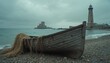 © Viktor - Old weathered wooden boat rests on pebble shore near sea waves. Distant lighthouse structure and buildings on overcast day. Nautical seascape conveys solitude and calm with fishing net detail.