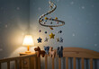 © Ali - A handcrafted spiral mobile with felt animals hanging in a baby's nursery during a snowy winter afternoon, the room lit by a warm lamp, casting soft shadows on the wooden crib and pale blue walls, wi
