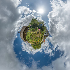 Wall Mural - simple tiny planet with wooden home or homestead building in blue sky with beautiful clouds. transfo