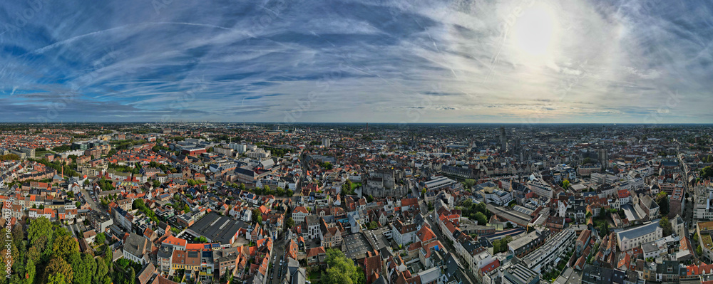 Aerial view of the historic cityscape with distinctive brick buildings under a vast sky, Ghent, Flanders, Belgium.