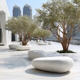 Outdoor plaza with smooth, pebble-shaped benches, lush trees, and modern architecture