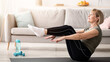 © Prostock-studio - Athletic senior woman doing abs exercises, sitting in boat yoga pose at home, free space. Full length portrait of fit mature lady doing domestic training during coronavirus epidemic