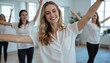 © miss irine - Woman leads group exercise session in bright office space. Team enjoys physical activity, stretching, promotes teamwork, productivity, well-being. Trainer guides participants in wellness break.
