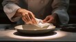 © Nattapol - Chef cleaning plate rim with towel before final presentation under spotlight