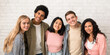 © Prostock-studio - Friendship of exchange students and modern education. Happy young multiracial people team in casual hugging in college or university, smiling and looking at camera, on white brick wall background
