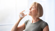 © Prostock-studio - Fit senior woman drinking clear water during her workout break at home. Mature Caucasian lady staying hydrated after sports training. Healthy lifestyle and wellness concept