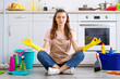 © Prostock-studio - Young housewife surrounded by cleaning supplies meditating on floor at kitchen, taking break from house chores. Millennial maid resting from domestic duties, finding balance between life and home work