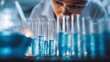 © nur khayati w - Focused scientist examines test tubes filled with liquid