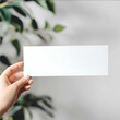© gogu - POV shot of a persons hand holding a long rectangle blank white bumper sticker to the camera product photo product mockup