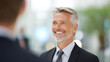 © Akash - smiling businessman talking colleague office success