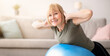 © Prostock-studio - Smiling senior woman doing exercises with fitness ball at home, space for text. Mature Caucasian lady working out her back muscles, training with sports equipment during coronavirus lockdown