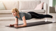 © Prostock-studio - Domestic workout concept. Athletic senior woman standing in elbow plank on yoga mat at home. Sporty mature lady working out indoors, strengthening her core muscles during covid lockdown
