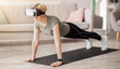 © Prostock-studio - Exercising with virtual reality concept. Mature woman in VR headset standing in plank pose at home. Strong senior lady using modern technologies for domestic yoga workout