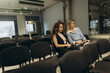 © Roman - Two Women Sitting in an Empty Auditorium Observing a Professional Presentation