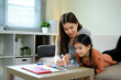 © Prathankarnpap - Loving mother helping daughter with homework or art project in a bright living room