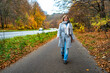 © Jacek Chabraszewski - Beautiful mature woman walking on sidewalk in autumn scenery. Front view
