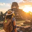 © Buka - Woman with backpack admires ancient ruins at sunset