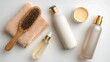© MDSakib - Hair care products including a wooden hairbrush, towel, shampoo, conditioner, serum, and lotion, arranged on a white background