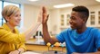 © SERHII - Teacher and student high-fiving in science classroom with solar system model