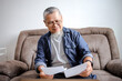 © Gatot - Asian Senior Man With Casual Outfit Doing Work From Home While Reviewing Document