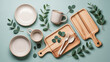 © Nazmul Karim Sakib - Flat lay of rustic ceramic tableware and wooden serving boards with eucalyptus leaves on a teal background