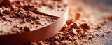 Close up of crushed cocoa powder and chocolate tablet on wooden table in a warm light setting