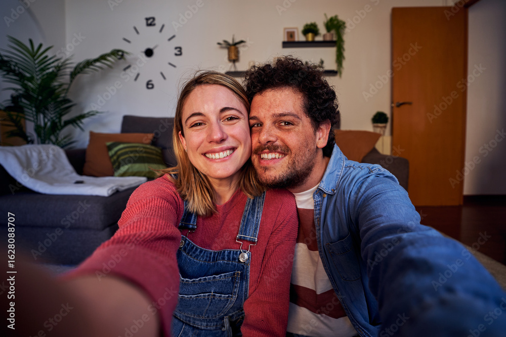 Happy selfie of a caucasian young couple at home using smartphone to ...