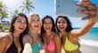 © meeblues - Four diverse and happy friends on a tropical beach take a selfie with a tablet. An image for friendship, travel, and unforgettable summer memories