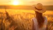 © Naila - A woman in a straw hat stands in a wheat field at sunset, enjoying the golden light and the beauty of nature, with a sense of peace and freedom in the countryside