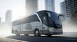 © GS-Studio - A modern grey tour bus is seen speeding down a city street with sunlight illuminating it