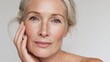 © Johannes - 50s mid aged woman touching face skin looking at camera attractive mature old woman looking at camera isolated on white background advertising dry skin care treatment anti age skincare close up view