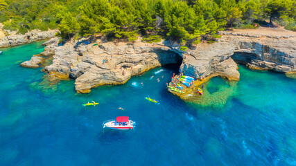 Wall Mural - aerial view on coast with rocks and forest. boat and kayaks in the bay. vacation and relax at the su