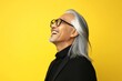 © R - Yellow solid background. Modish men's two-block cut haircut - midlife southeast asian man with long hair. A trendy and poised male showing charm. Idea of style for aging men.