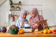 © Art_Photo - Muslim girl cooking with woman using tablet for recipe, halal food learning with technology, warm islamic family lifestyle, digital nutrition education for muslim kid, modern halal kitchen inspiration
