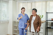 © Ekkasit A Siam - Asian female physiotherapist encourages senior asian female patient using walker during rehabilitation session while giving thumbs up in clean clinic room with natural lighting