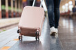 © Phimwilai - Tourist walking with rolling suitcase in train station
