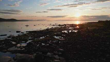 Wall Mural - drone shot of a sunset over a rocky coastline on the stora lulevatten in norrbotten county, sweden