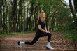 © dsheremeta - Woman stretching in forest during outdoor exercise