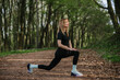 © dsheremeta - Sporty woman stretching legs in the woods before running