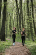 © dsheremeta - Women jogging through a serene forest trail