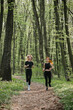 © dsheremeta - Two women running in the forest wearing sportswear
