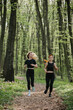 © dsheremeta - Women jogging through a lush forest trail
